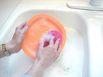 Plastic plate being scrubbed clean.